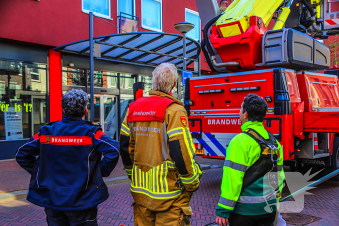 Duif gered uit benarde positie achter glazen balustrade