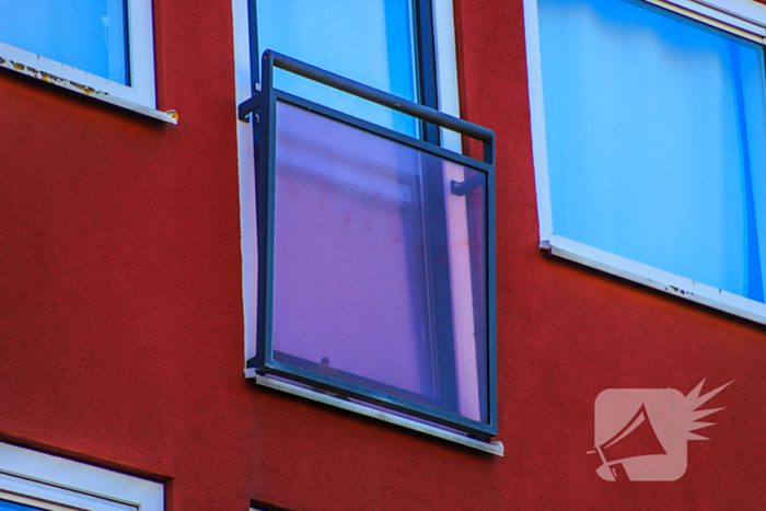 Duif gered uit benarde positie achter glazen balustrade