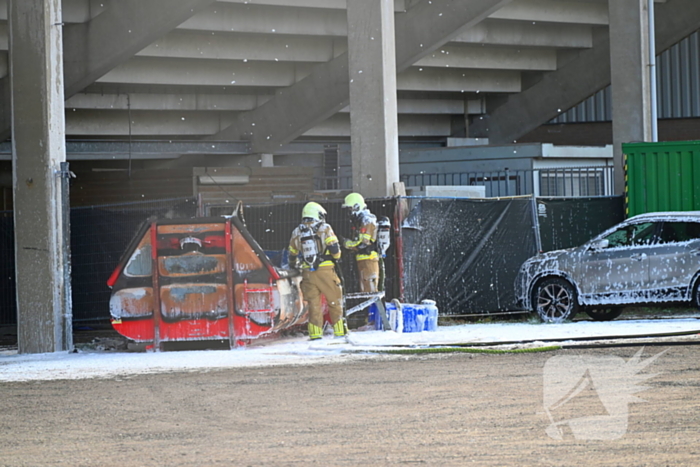 Container in brand onder tribune