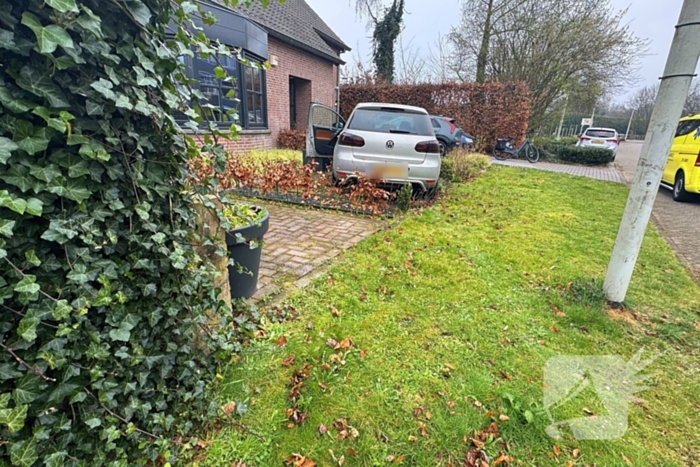Automobilist rijdt voortuin in