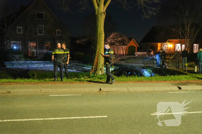 Auto raakt bij botsing met boom te water