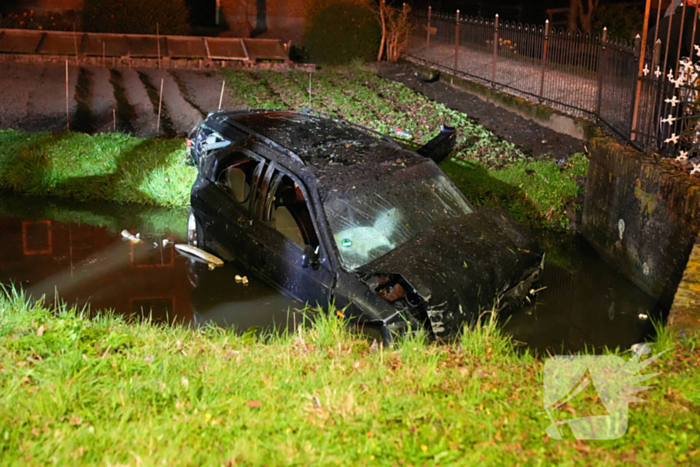 Auto raakt bij botsing met boom te water