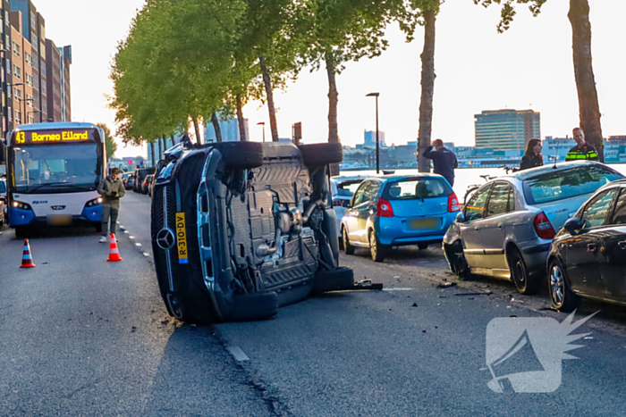 Auto botst op drie geparkeerde auto's en belandt op zijkant