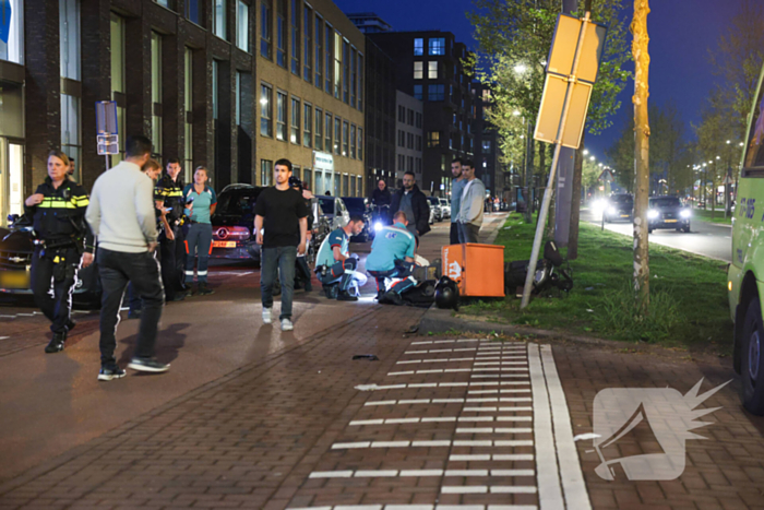 Maaltijdbezorger klapt tegen auto en komt ten val