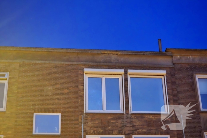 Brokstukken op stoep van gevel