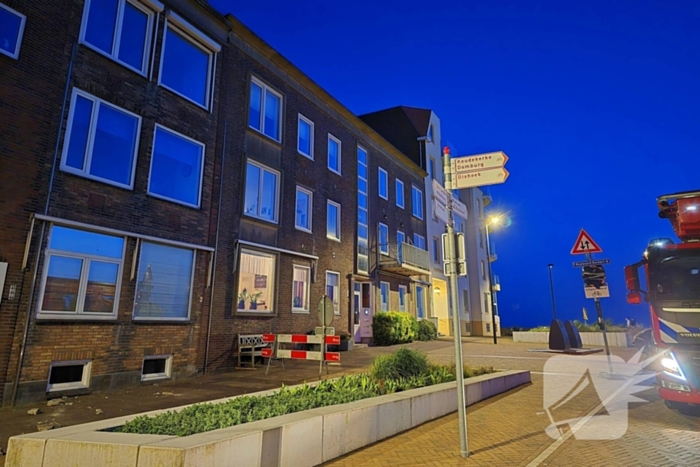 Brokstukken op stoep van gevel