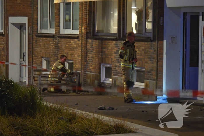 Brokstukken op stoep van gevel