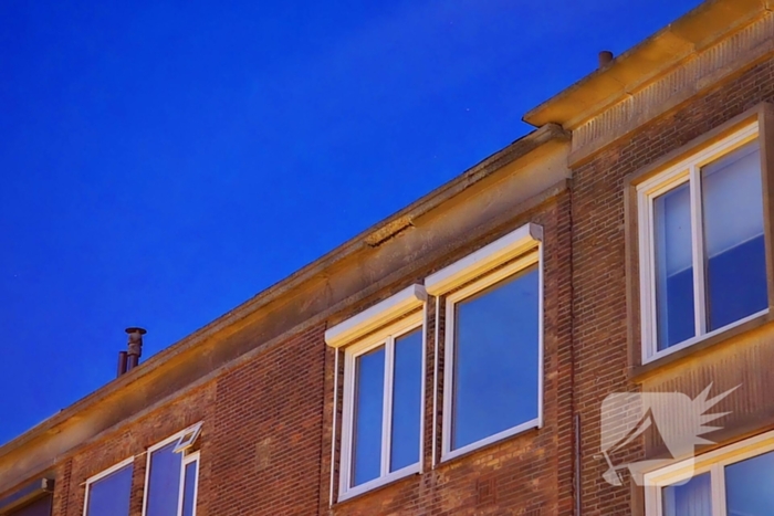 Brokstukken op stoep van gevel