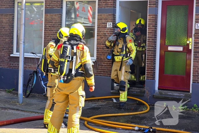 Brandweer slaat raam in wegens brand