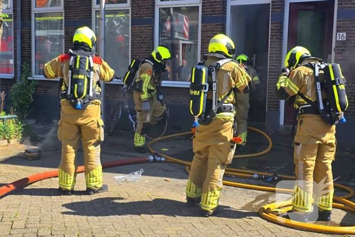 Brandweer slaat raam in wegens brand