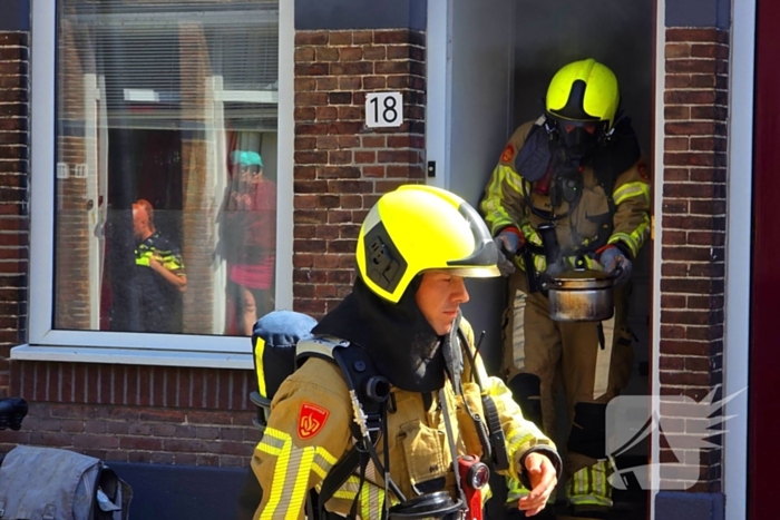 Brandweer slaat raam in wegens brand
