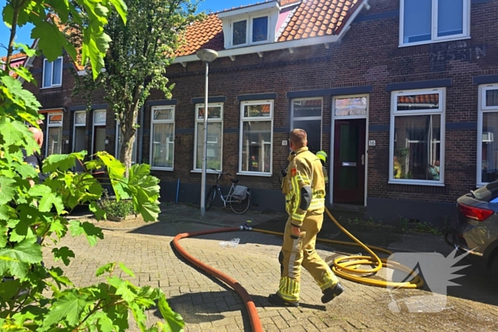Brandweer slaat raam in wegens brand