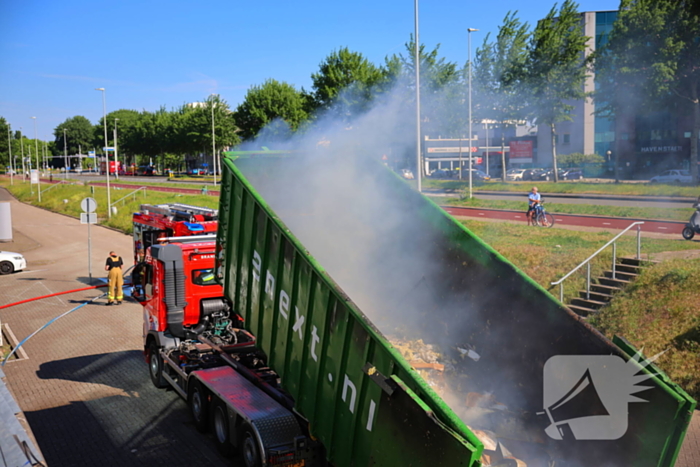 Vlammen slaan uit grote afvalcontainer