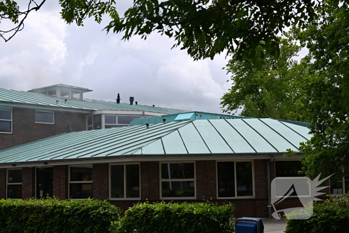 Rook uit dak van schoolgebouw