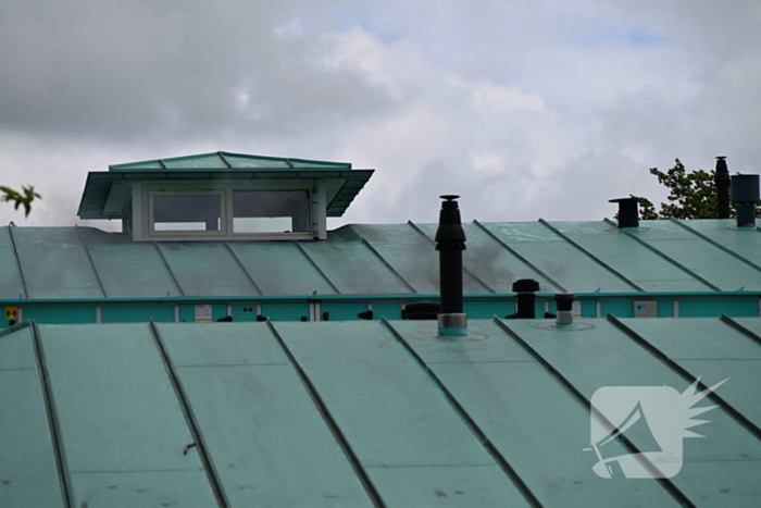 Rook uit dak van schoolgebouw