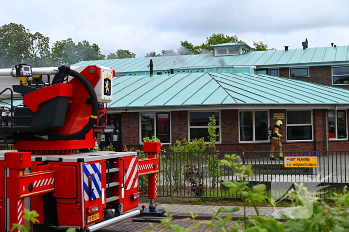 Rook uit dak van schoolgebouw