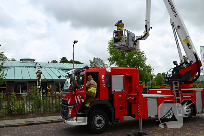 Rook uit dak van schoolgebouw