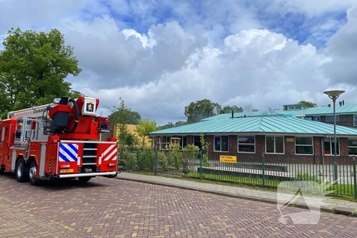 Rook uit dak van schoolgebouw