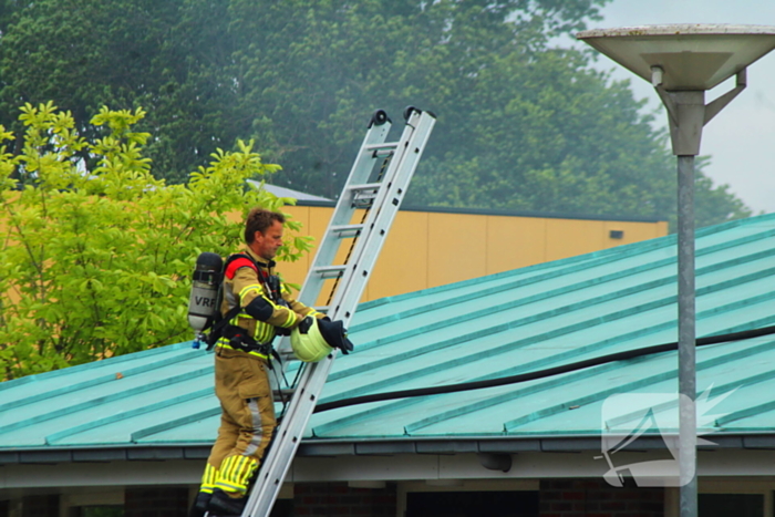 Rook uit dak van schoolgebouw
