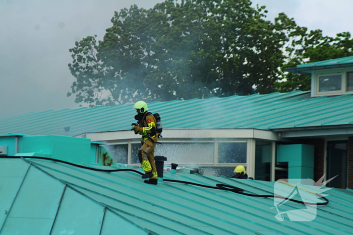 Rook uit dak van schoolgebouw