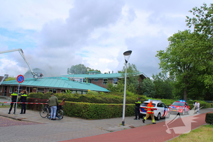Rook uit dak van schoolgebouw
