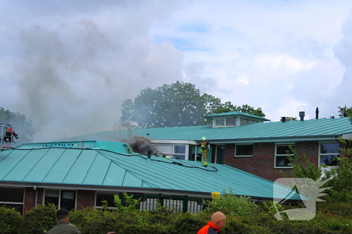 Rook uit dak van schoolgebouw