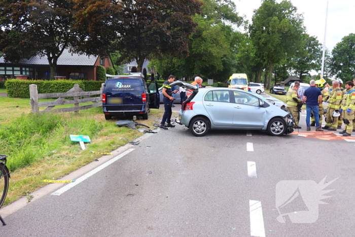 Bestelbus en personenauto met elkaar in botsing, brandweer assisteert bij bevrijding automobilist