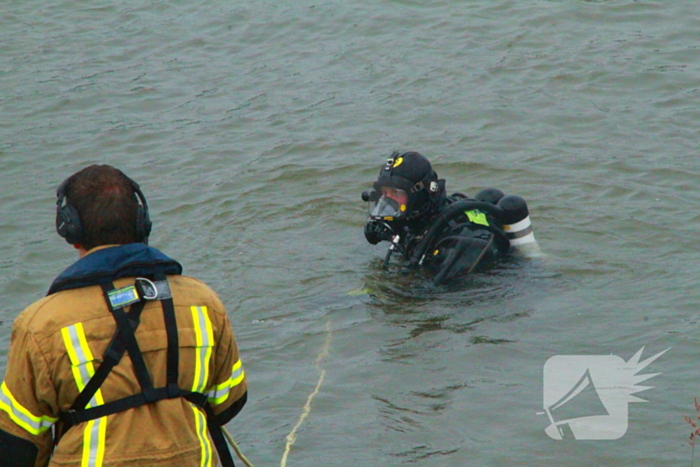 Duikers zoeken naar auto in rivier