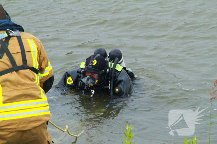 Duikers zoeken naar auto in rivier