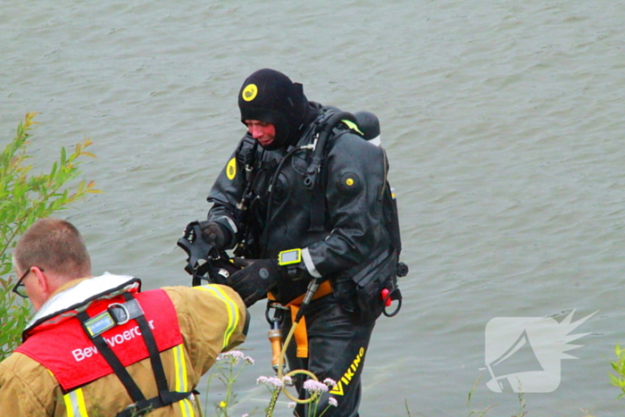 Duikers zoeken naar auto in rivier