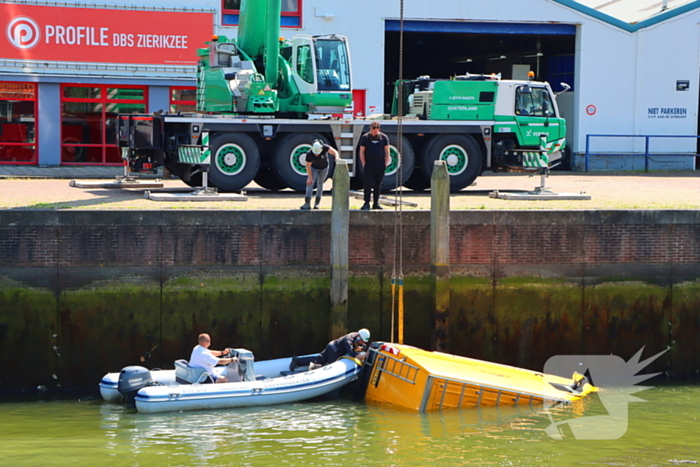 Te water geraakte werkbus door kraan uit water gehaalt