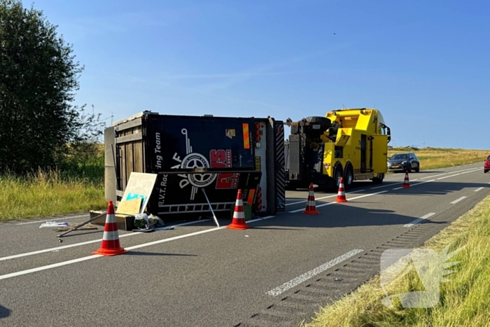 Vrachtwagen kantelt na slip