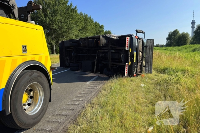 Vrachtwagen kantelt na slip