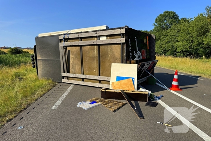 Vrachtwagen kantelt na slip