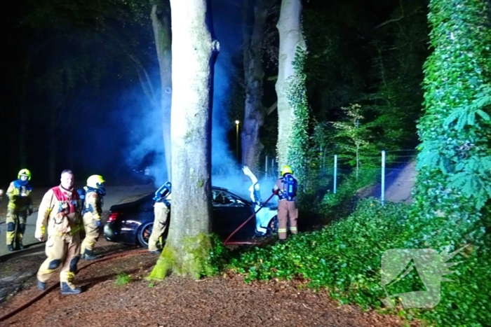 Brandweer blust auto van  250000 00 op parkeerplaats die vlam vat