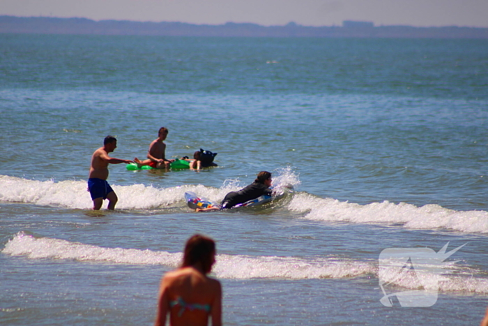 Mens en dier zoeken verkoeling aan het strand