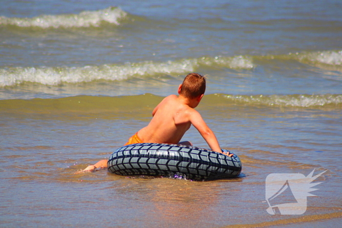 Mens en dier zoeken verkoeling aan het strand