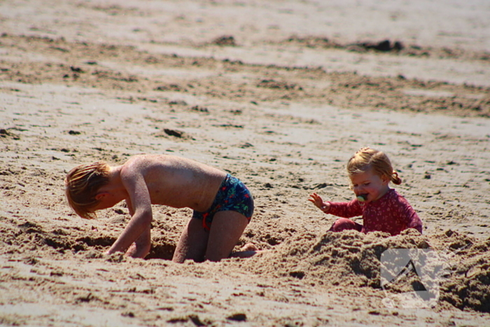 Mens en dier zoeken verkoeling aan het strand