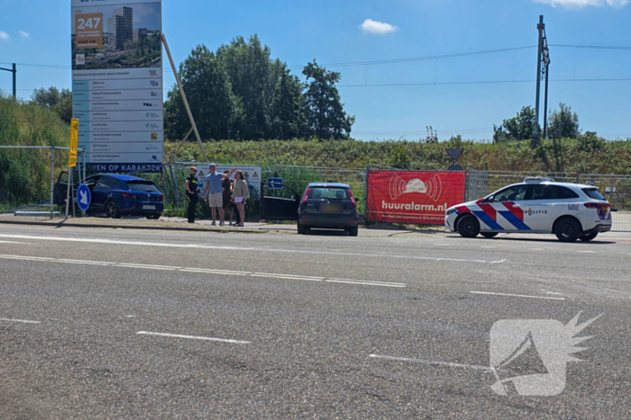 Automobilist ramt hekwerk bij bouwplaats
