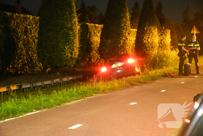 Auto mist bocht en raakt te water