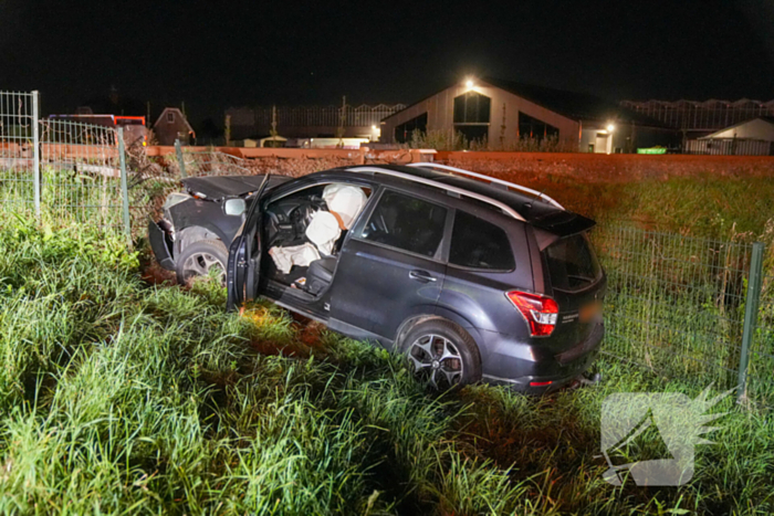 Auto vliegt uit de bocht en knalt tegen hek bij spoorwegovergang