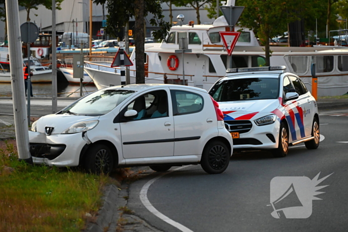 Auto crasht op rotonde en raakt paal