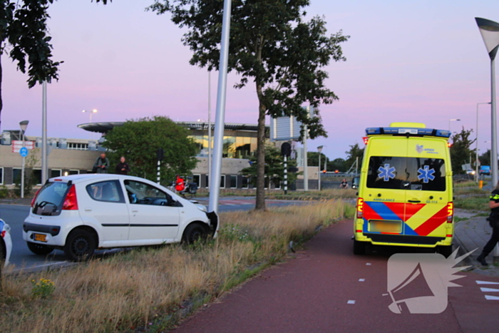 Auto crasht op rotonde en raakt paal