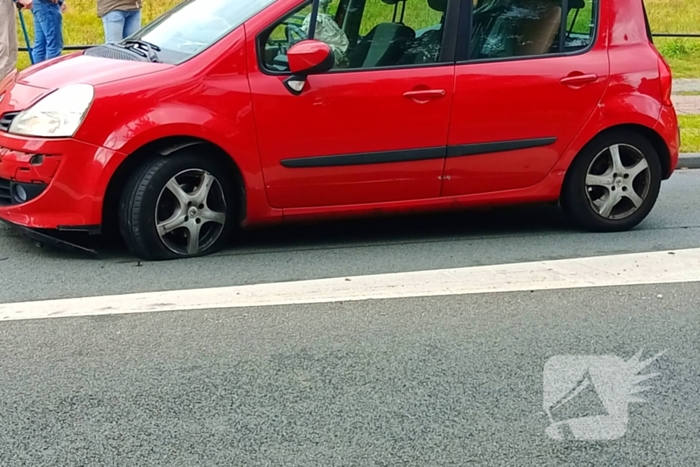 Personenauto botst tegen vluchtheuvel en krijgt lekke band