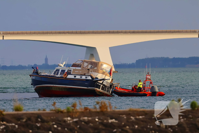Boot loopt vast op dam, bergingsbedrijf schiet te hulp