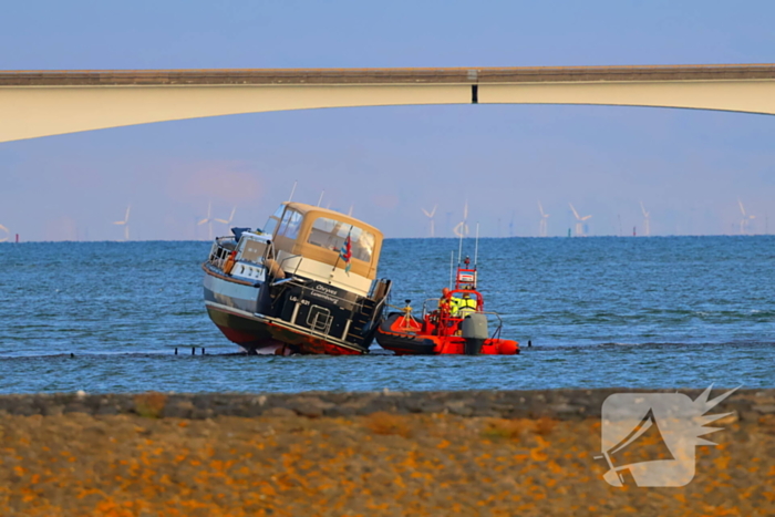 Boot loopt vast op dam, bergingsbedrijf schiet te hulp