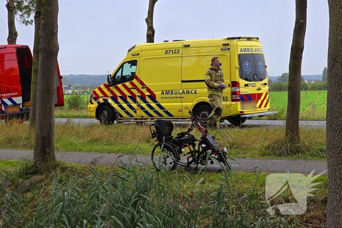 persoon op driewielfiets in water beland