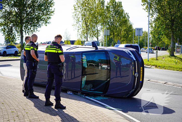 Bestelbus op zijn kant na botsing