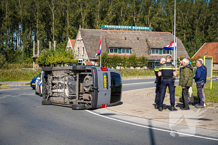Bestelbus op zijn kant na botsing