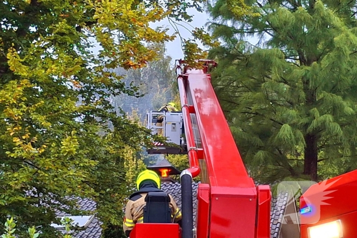 Vlammen slaan uit schoorsteen